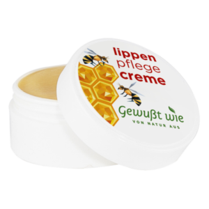 Weißer Tiegel mit Lippenpflegecreme, dekoriert mit Bienen und einem Honigwaben-Motiv.