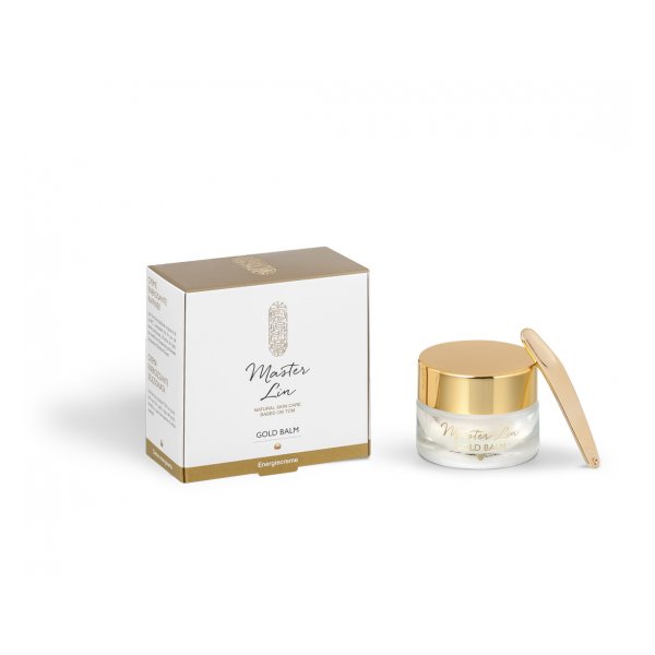 Ein Glasbehälter mit goldfarbenem Deckel, neben einer schlichten, weißen Verpackung mit goldenen Akzenten.