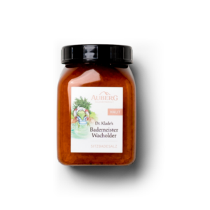 Ein Glasbehälter mit Deckel, gefüllt mit Badesalz, beschriftet als "Dr. Klade's Bademeister Wacholder".