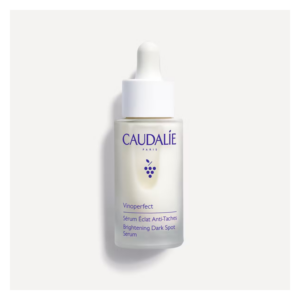 Flasche mit hellbeigem Serum von CAUDALIE, mit Pipette und lila Schriftzug, zur Hautaufhellung.