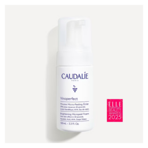 Flasche mit Micro-Peeling-Schaum von CAUDALIE, weiß mit blauen Schriftzügen, 100 ml, dekoriert mit Auszeichnungssiegel.