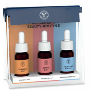 Drei Fläschchen Hautpflegeöle in einer transparenten Verpackung, beschriftet mit Vitamin C, Retinol und Argirelin.