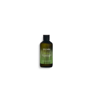 Grüne Flasche mit schwarzem Deckel, beschriftet mit "DOLMIA HAIR DETOX Feuchtigkeits-Shampoo" und Gräsern im Hintergrund.