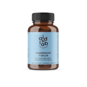 Braune Glasflasche mit schwarzem Deckel, gefüllt mit Magnesiumtabletten. Beschriftet mit 'Magnesium 7 Salze'.