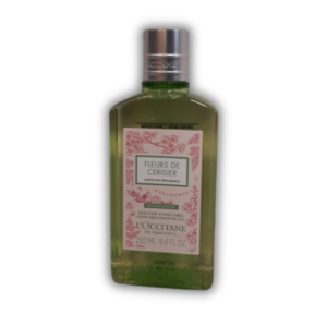 Flasche mit grünem Duschgel von L'Occitane, etiketiert mit "FLEURS DE CERISIER", im beschränkten Design.