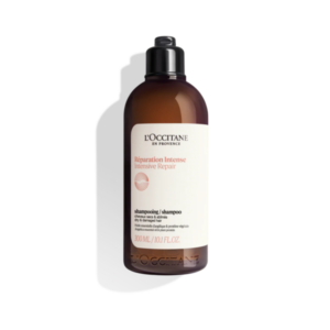 Braune Flasche mit Shampoo für trockene und geschädigte Haare, mit leicht lesbarem Etikett und schwarzem Deckel.